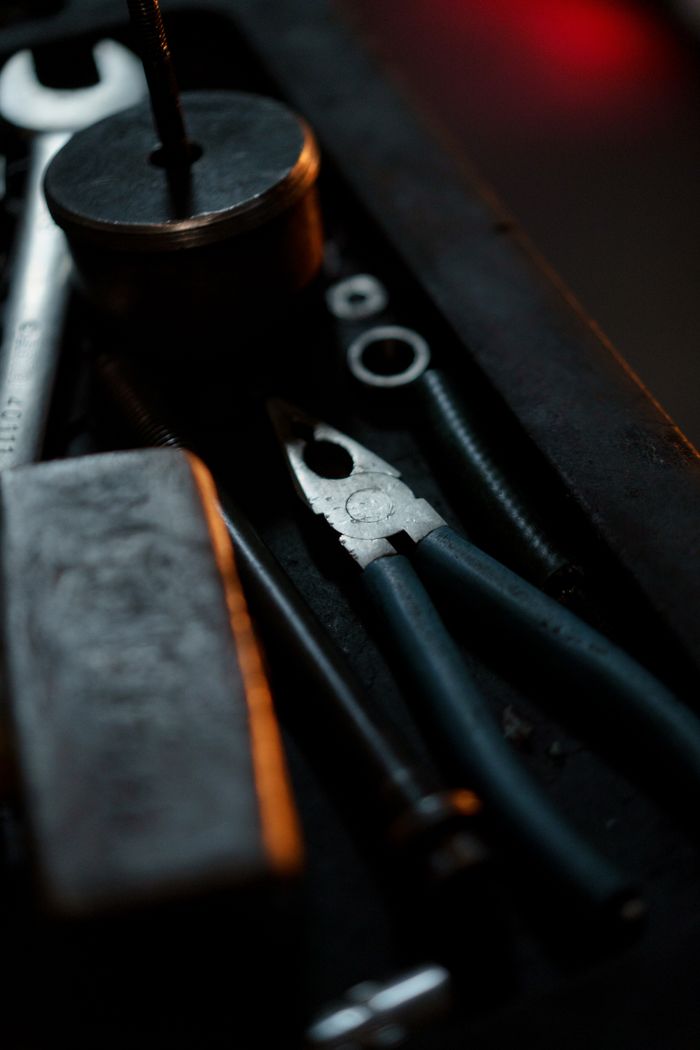 Detailed close-up of various tools like pliers and wrench in a workshop setting.